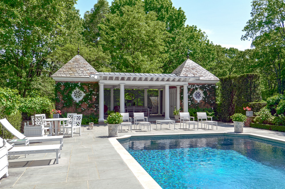 Modelo de casa de la piscina y piscina elevada tradicional pequeña rectangular en patio trasero con adoquines de ladrillo