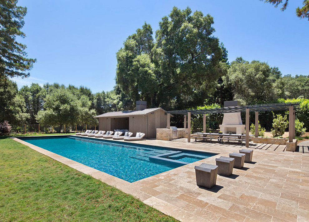 Imagen de casa de la piscina y piscina campestre grande rectangular en patio trasero con adoquines de piedra natural
