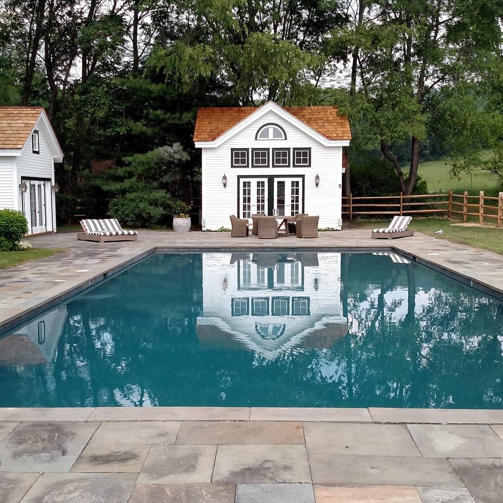 Aménagement d'une piscine arrière classique rectangle avec des pavés en pierre naturelle.