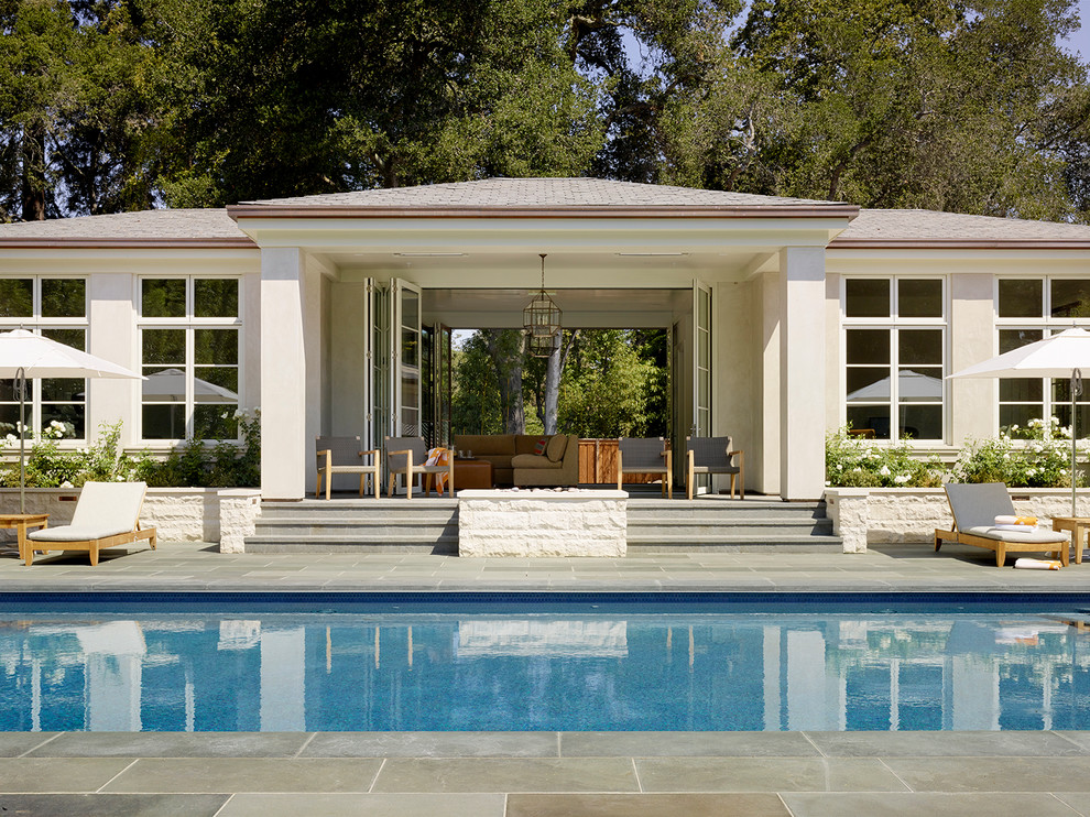 Diseño de casa de la piscina y piscina alargada clásica renovada extra grande rectangular en patio trasero con adoquines de piedra natural