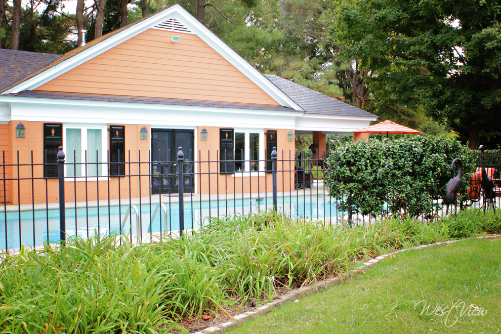 This is an example of a medium sized nautical back rectangular swimming pool in Richmond with a pool house and stamped concrete.