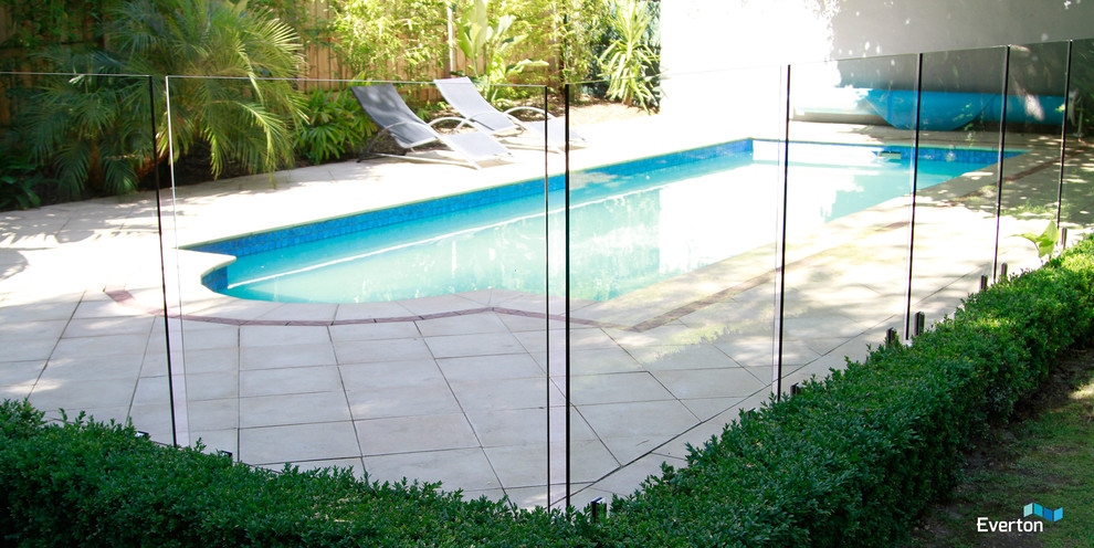 Modern inredning av en anpassad pool på baksidan av huset, med naturstensplattor