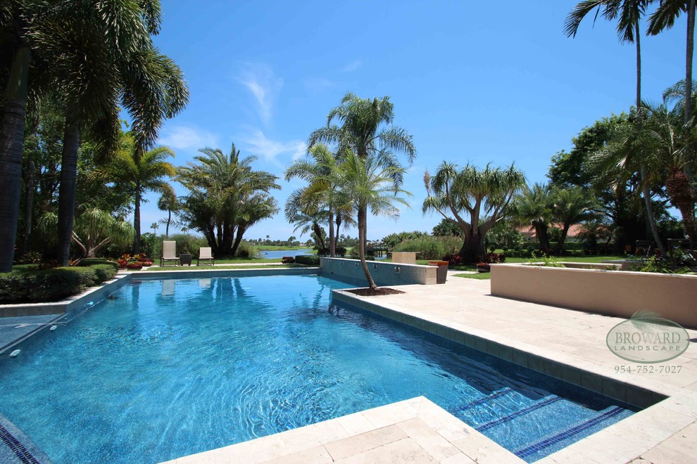 Modelo de piscina contemporánea extra grande en patio trasero con adoquines de piedra natural