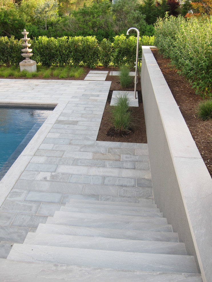 Imagen de piscina asiática de tamaño medio rectangular en patio trasero con adoquines de piedra natural