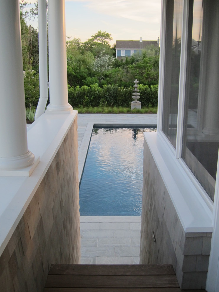Inspiration for a medium sized world-inspired back rectangular swimming pool in New York with natural stone paving.