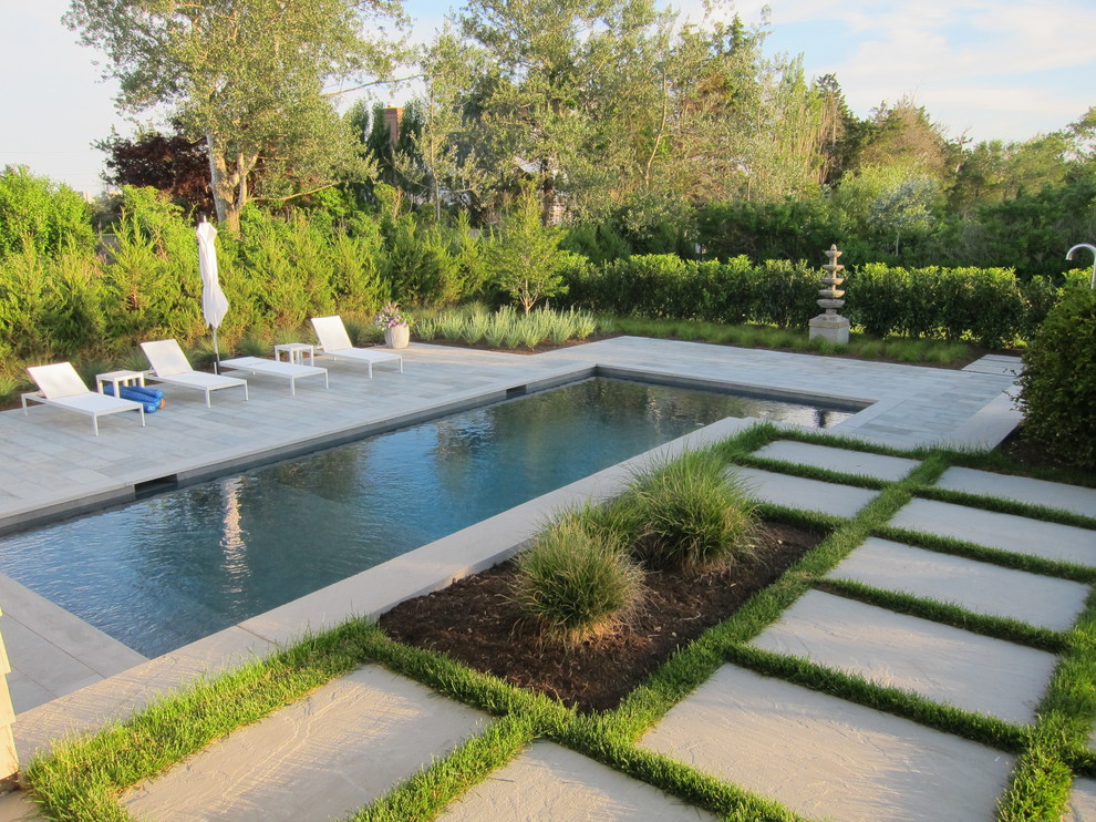 Diseño de piscina de estilo zen de tamaño medio rectangular en patio trasero con adoquines de piedra natural