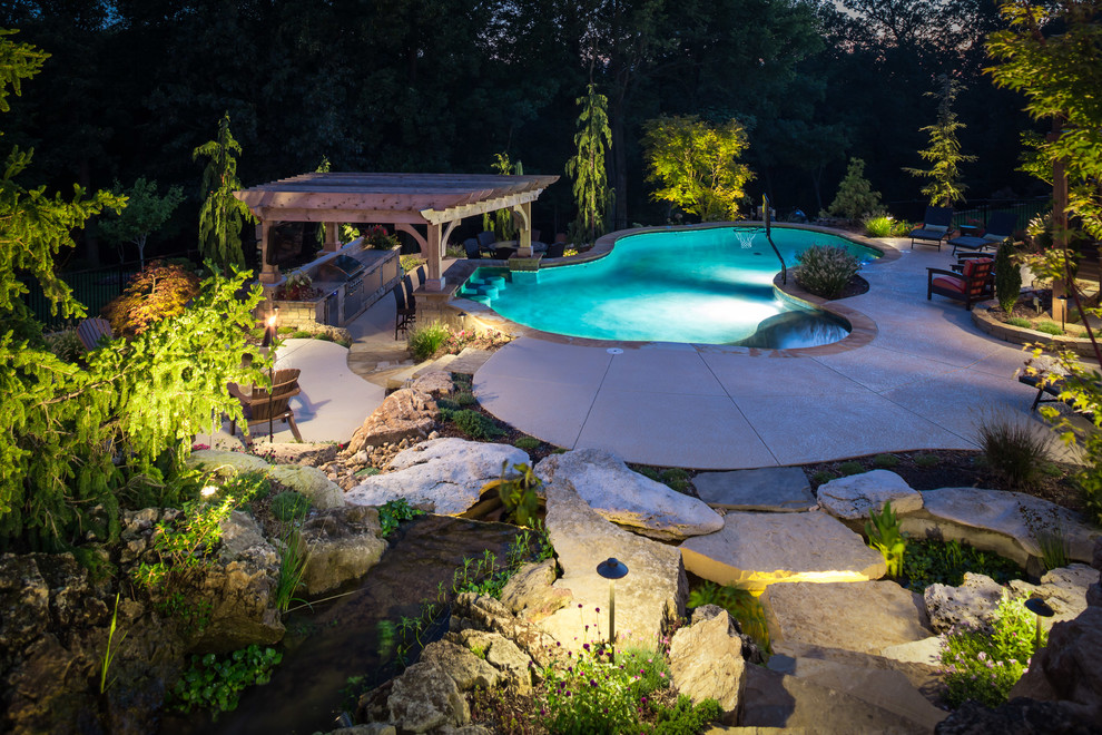Ispirazione per una grande piscina naturale chic personalizzata dietro casa con lastre di cemento