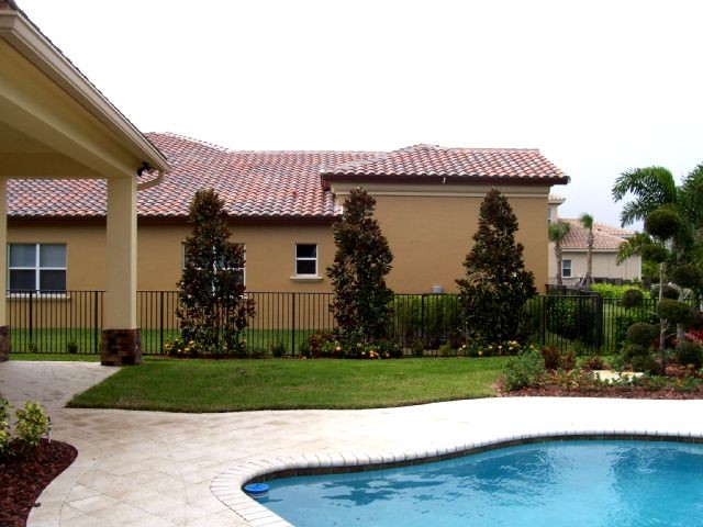 Immagine di una grande piscina naturale tropicale personalizzata dietro casa con fontane e pavimentazioni in mattoni