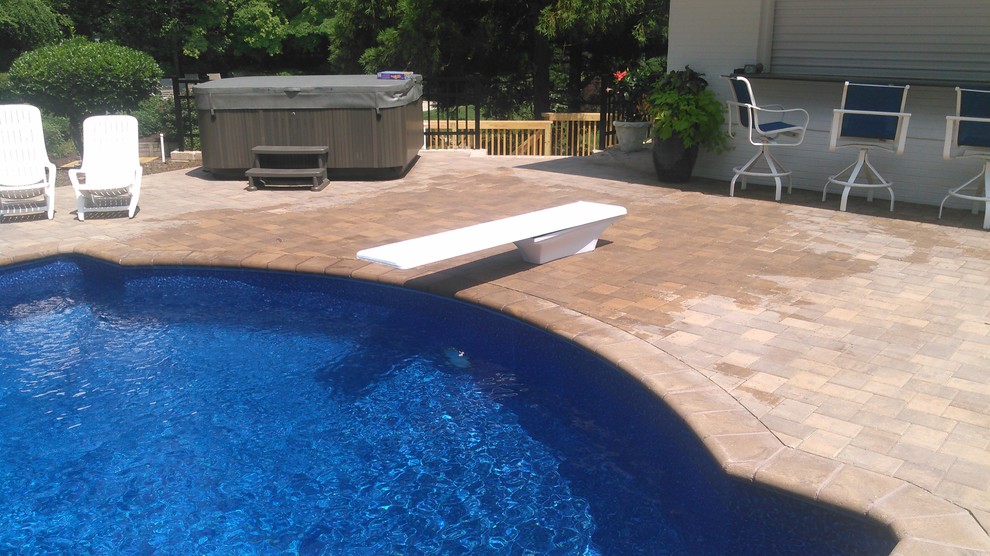 Idée de décoration pour une piscine arrière design de taille moyenne avec des pavés en béton.