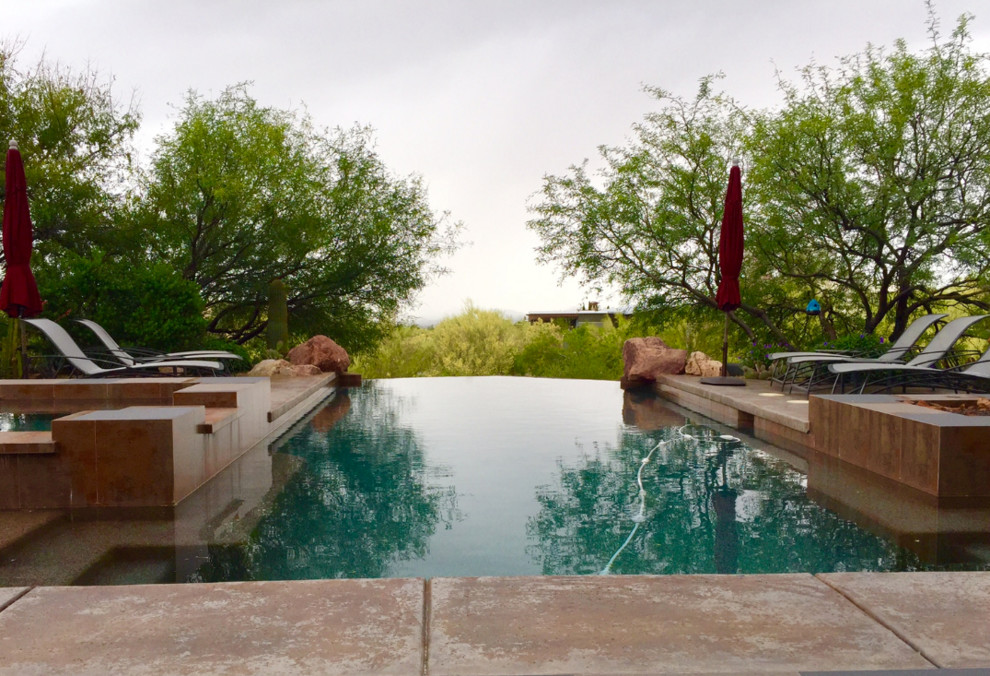 Imagen de piscinas y jacuzzis infinitos vintage de tamaño medio a medida en patio trasero con losas de hormigón