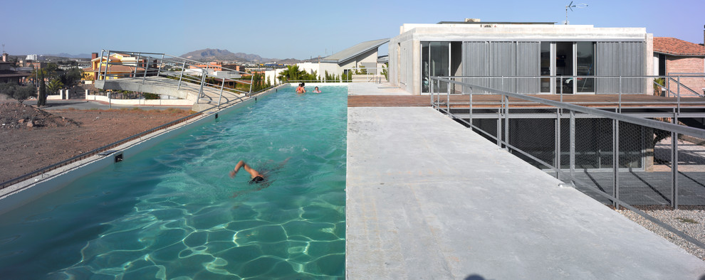 Foto di una piscina monocorsia minimal rettangolare di medie dimensioni e sul tetto con lastre di cemento