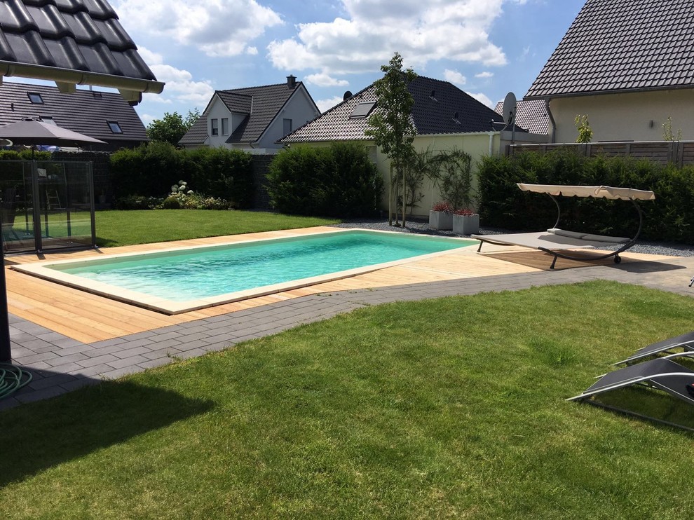 Cette image montre une piscine latérale design de taille moyenne et rectangle avec une terrasse en bois.