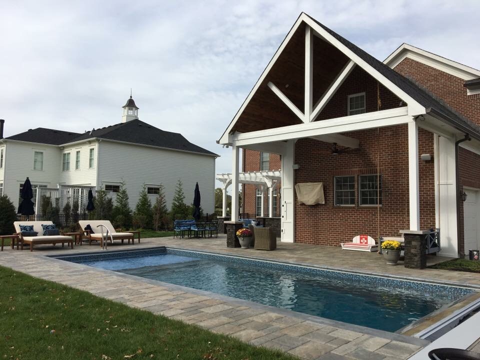 На фото: прямоугольный бассейн среднего размера на заднем дворе в морском стиле с мощением тротуарной плиткой