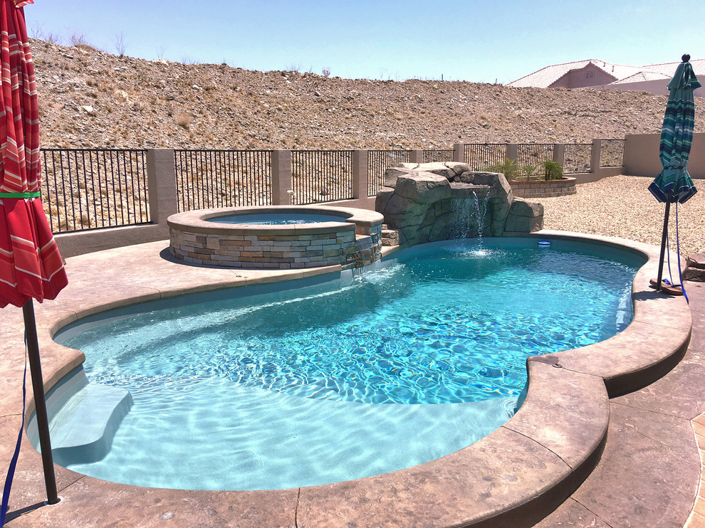 Idée de décoration pour une grande piscine arrière design ronde avec des pavés en pierre naturelle.