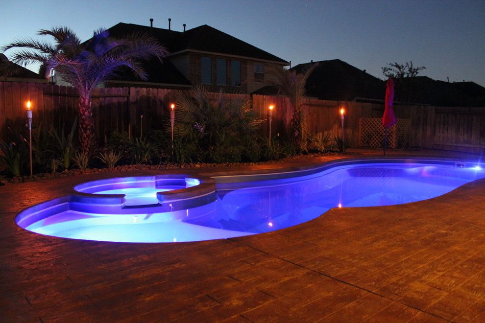 Foto de piscina actual de tamaño medio en patio trasero con entablado