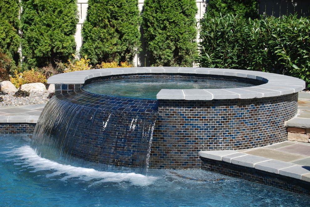 This is an example of a modern swimming pool in New York with a water feature.
