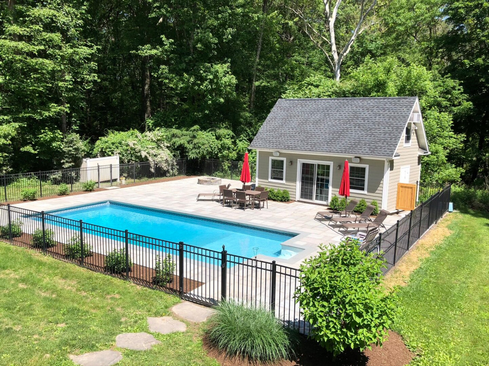 Contemporary back rectangular natural swimming pool in New York with with pool landscaping and natural stone paving.