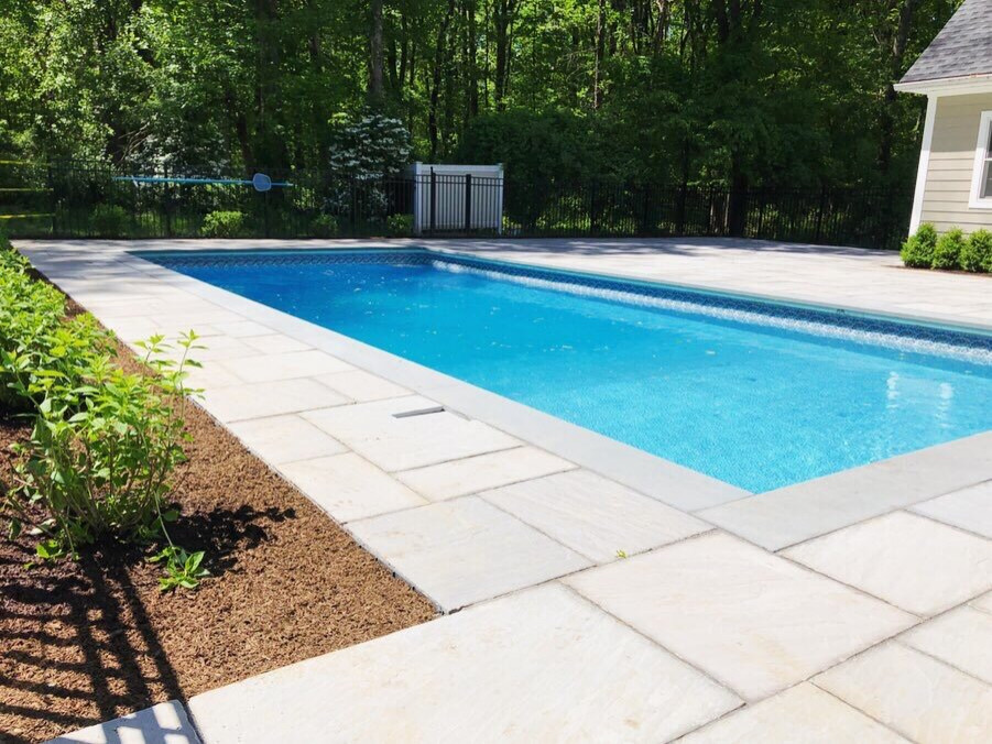 Foto de piscina natural contemporánea rectangular en patio trasero con paisajismo de piscina y adoquines de piedra natural