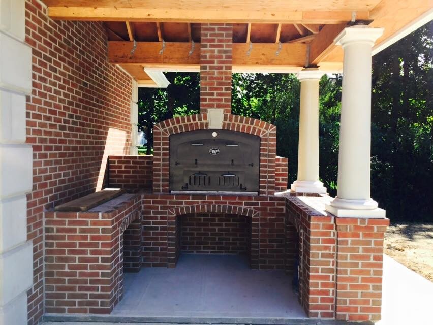 Immagine di un grande patio o portico tradizionale dietro casa con lastre di cemento