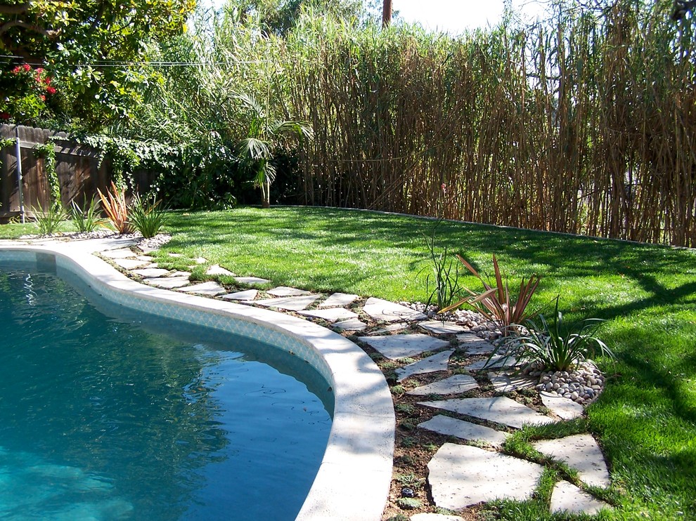 Pool - mid-sized traditional backyard concrete paver and custom-shaped lap pool idea in Los Angeles