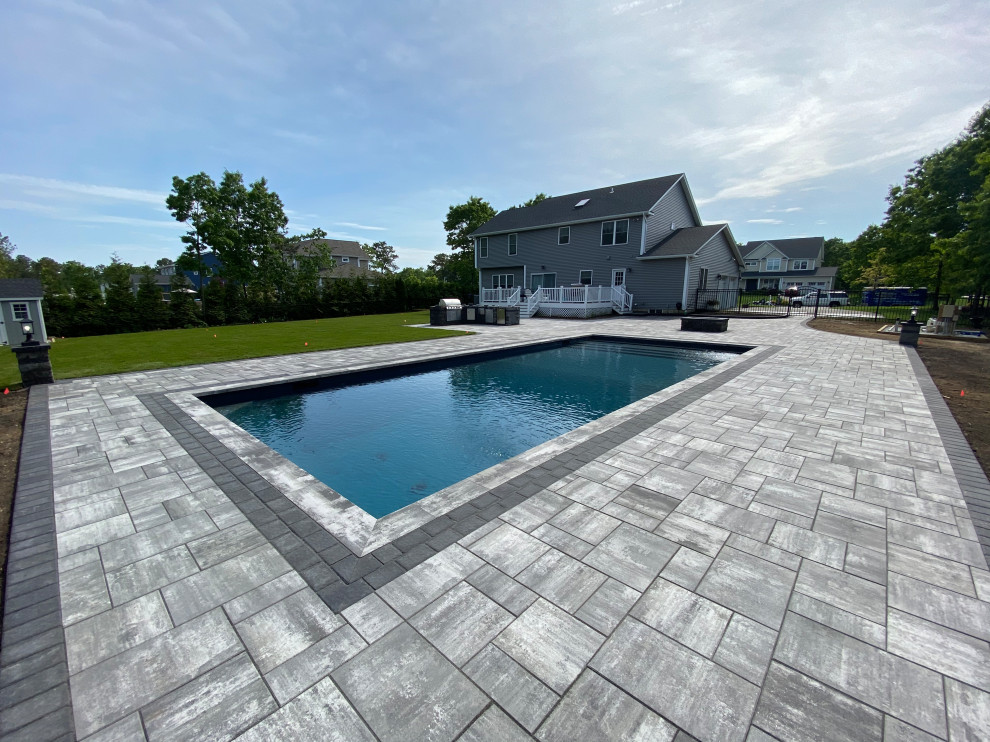 Inspiration for a huge modern backyard concrete paver and rectangular lap pool landscaping remodel in New York