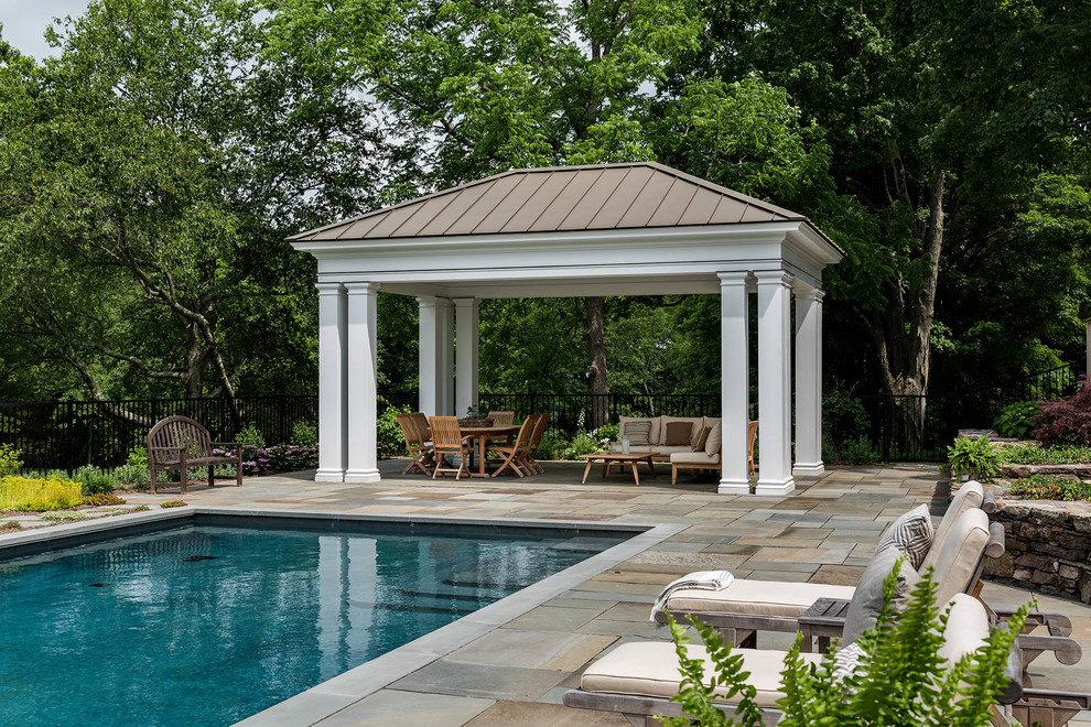 Foto de piscina clásica renovada de tamaño medio rectangular en patio trasero con adoquines de piedra natural