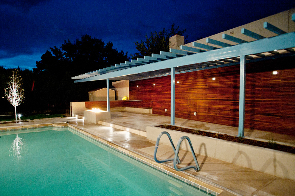 Example of a mid-sized trendy side yard stamped concrete and rectangular lap pool design in Albuquerque