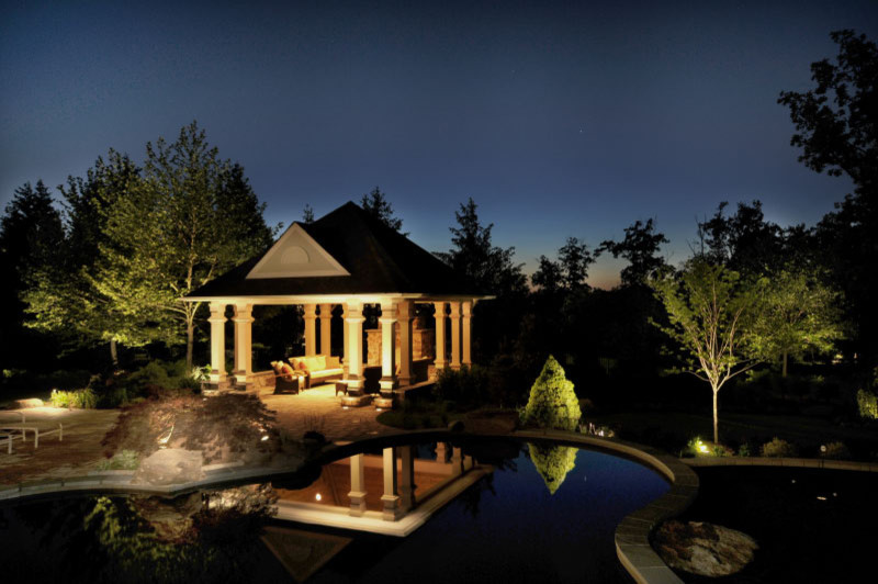 Foto de casa de la piscina y piscina natural actual extra grande a medida en patio trasero con adoquines de hormigón