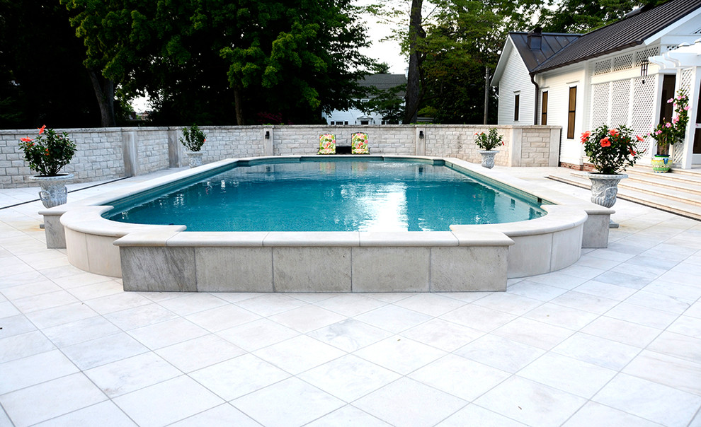 Photo of a large traditional back custom shaped above ground swimming pool in Other with stamped concrete.