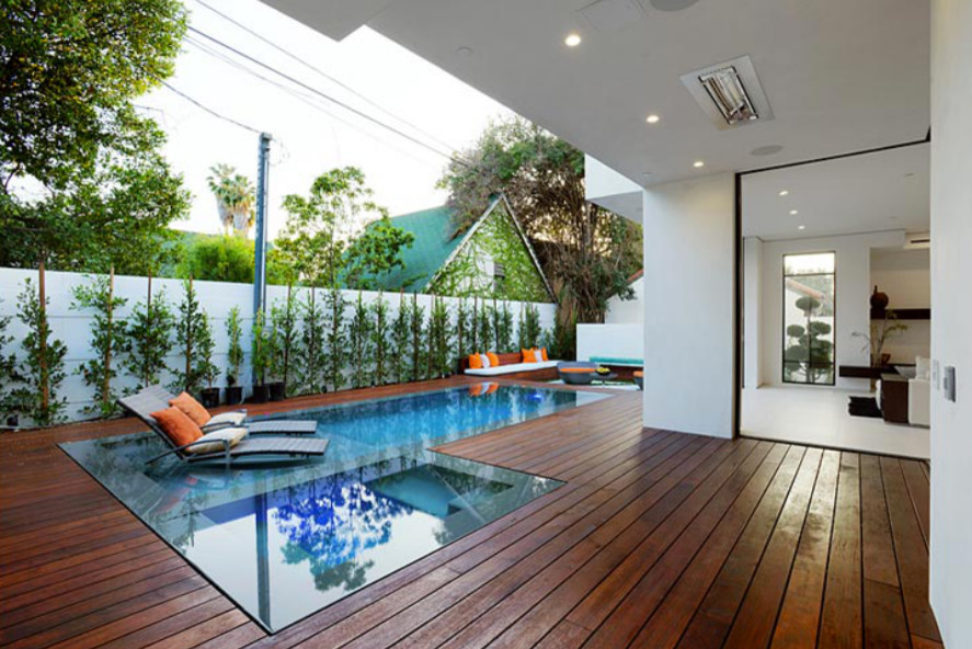 Esempio di una piscina monocorsia moderna a "L" di medie dimensioni e dietro casa con pedane