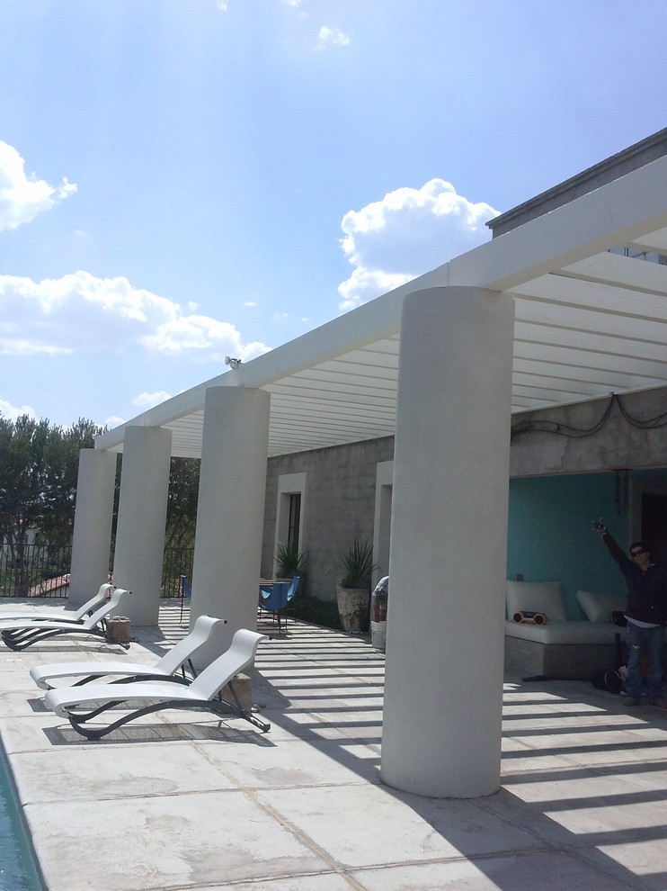 Imagen de piscina elevada costera grande rectangular en patio trasero con losas de hormigón