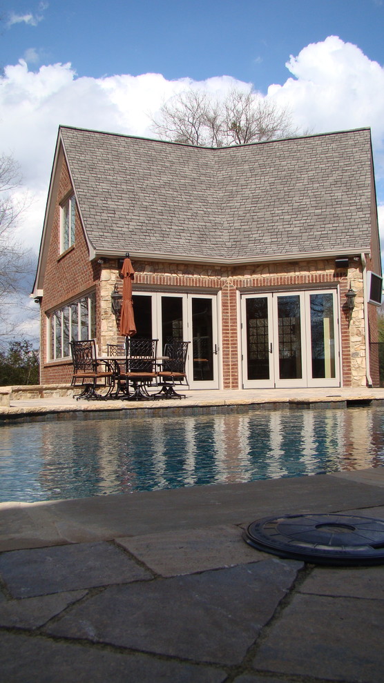 Example of a large classic backyard concrete paver and custom-shaped natural pool house design in Other