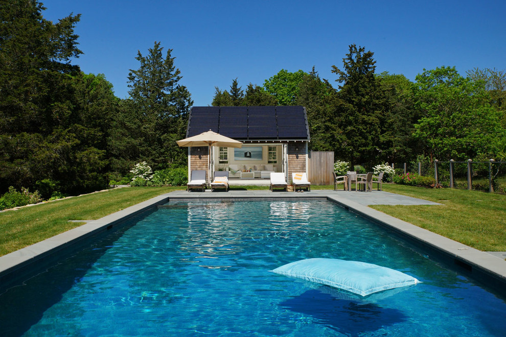 Cette image montre un très grand Abris de piscine et pool houses arrière rustique rectangle avec des pavés en pierre naturelle.