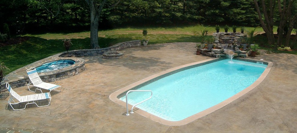 Immagine di una piscina a sfioro infinito chic rettangolare di medie dimensioni e dietro casa con pavimentazioni in pietra naturale