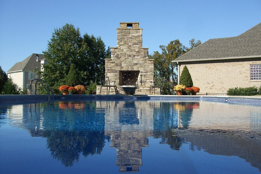 Idee per una grande piscina naturale tradizionale rettangolare dietro casa con pavimentazioni in cemento