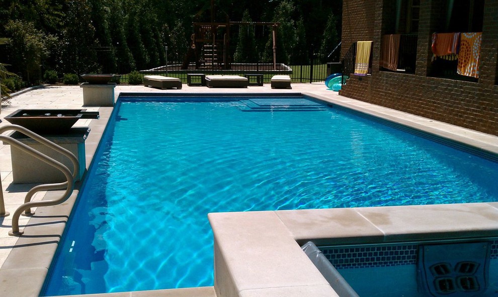 Aménagement d'une piscine naturelle et arrière classique de taille moyenne et rectangle avec des pavés en béton.