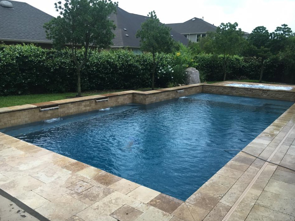 Esempio di una grande piscina naturale minimal rettangolare dietro casa con fontane e cemento stampato