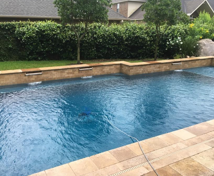 Modelo de piscina con fuente natural actual grande rectangular en patio trasero con suelo de hormigón estampado