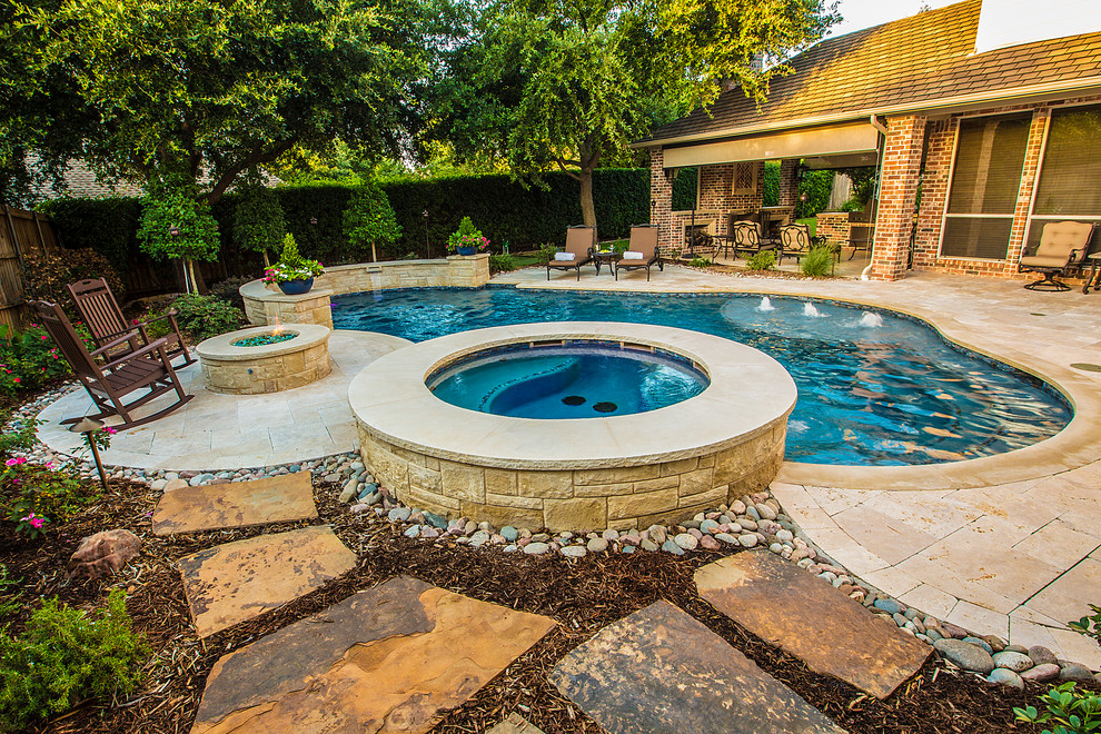 Diseño de piscina con fuente natural clásica de tamaño medio a medida en patio trasero con adoquines de piedra natural