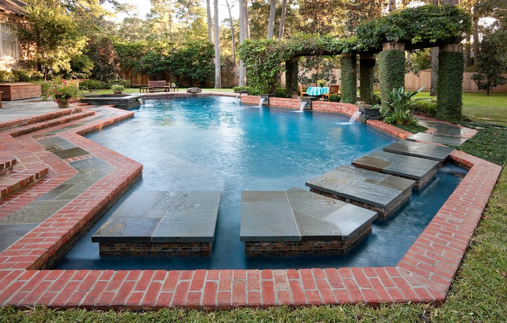 Diseño de piscina con fuente ecléctica grande a medida en patio trasero con adoquines de piedra natural