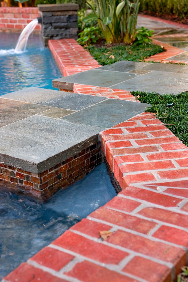 Photo of a small eclectic back custom shaped lengths swimming pool in Houston with a water feature and brick paving.