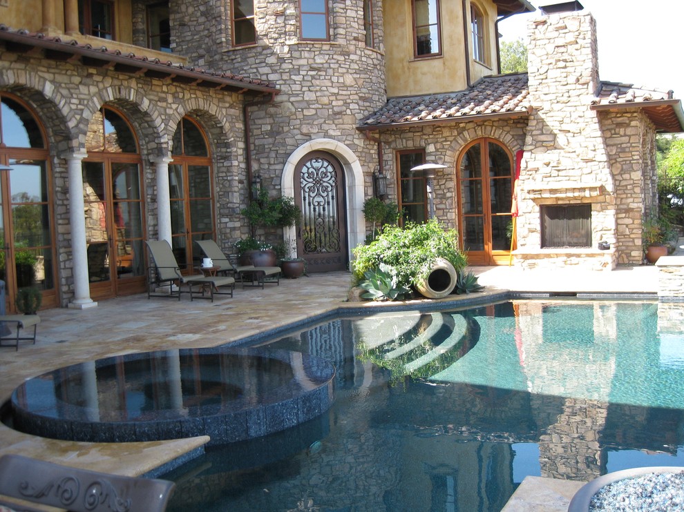 Immagine di una grande piscina contemporanea personalizzata dietro casa con una vasca idromassaggio e piastrelle