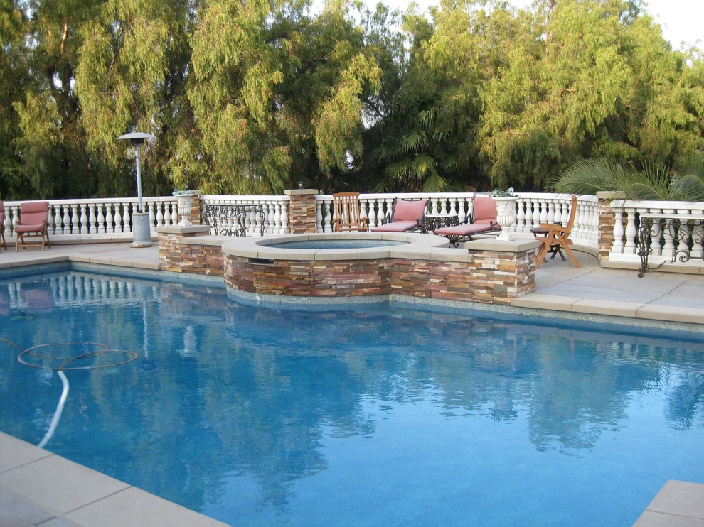 Foto di una piscina minimal rettangolare di medie dimensioni e dietro casa con una vasca idromassaggio e pavimentazioni in cemento