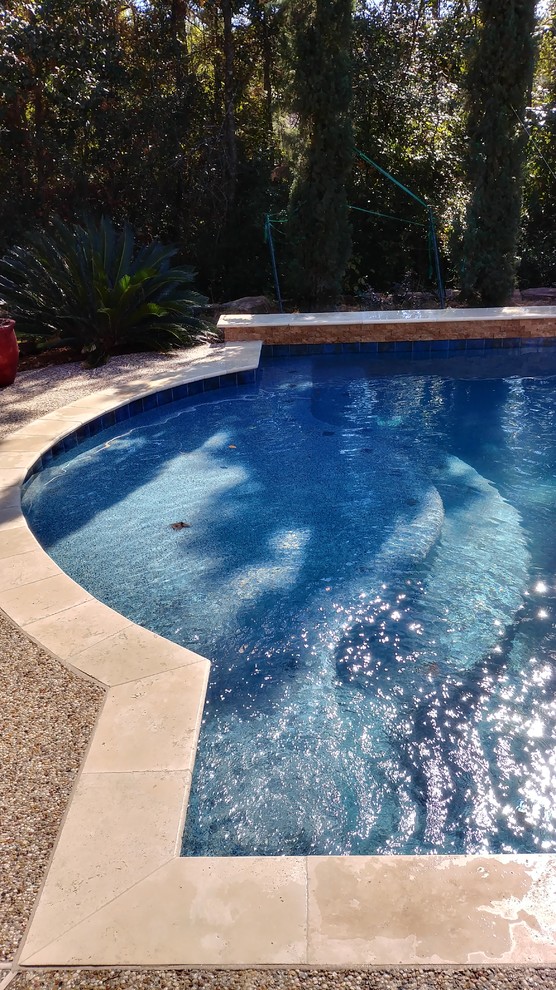 Пример оригинального дизайна: естественный, прямоугольный бассейн среднего размера на заднем дворе в средиземноморском стиле с джакузи и покрытием из бетонных плит