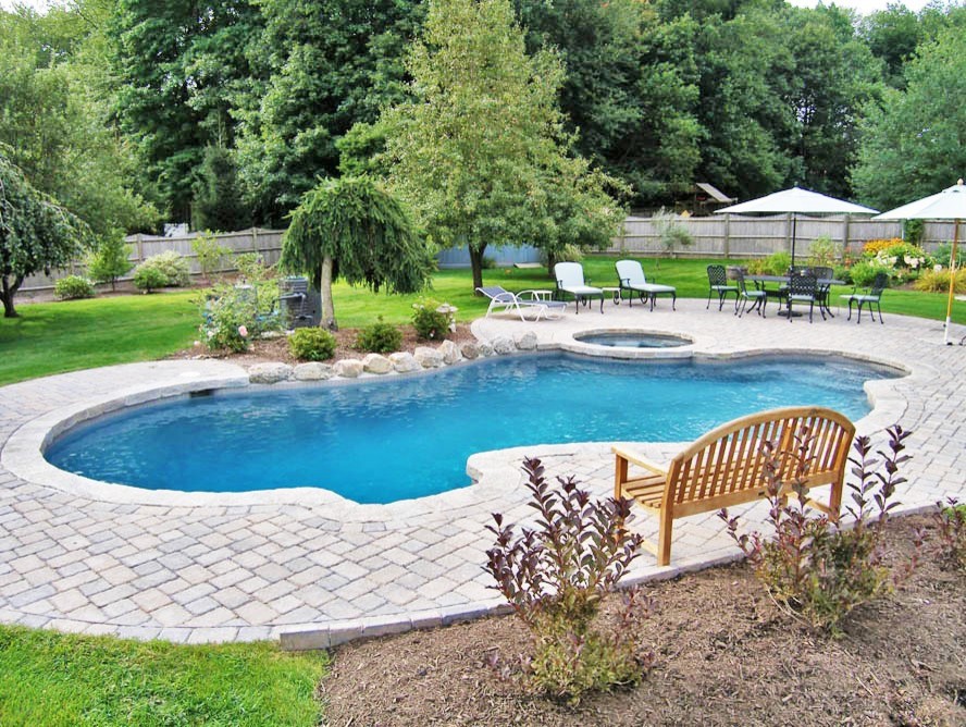 Ejemplo de piscinas y jacuzzis modernos grandes a medida en patio trasero con suelo de hormigón estampado