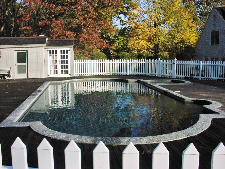 Идея дизайна: большой бассейн произвольной формы на заднем дворе в стиле модернизм с джакузи и покрытием из декоративного бетона
