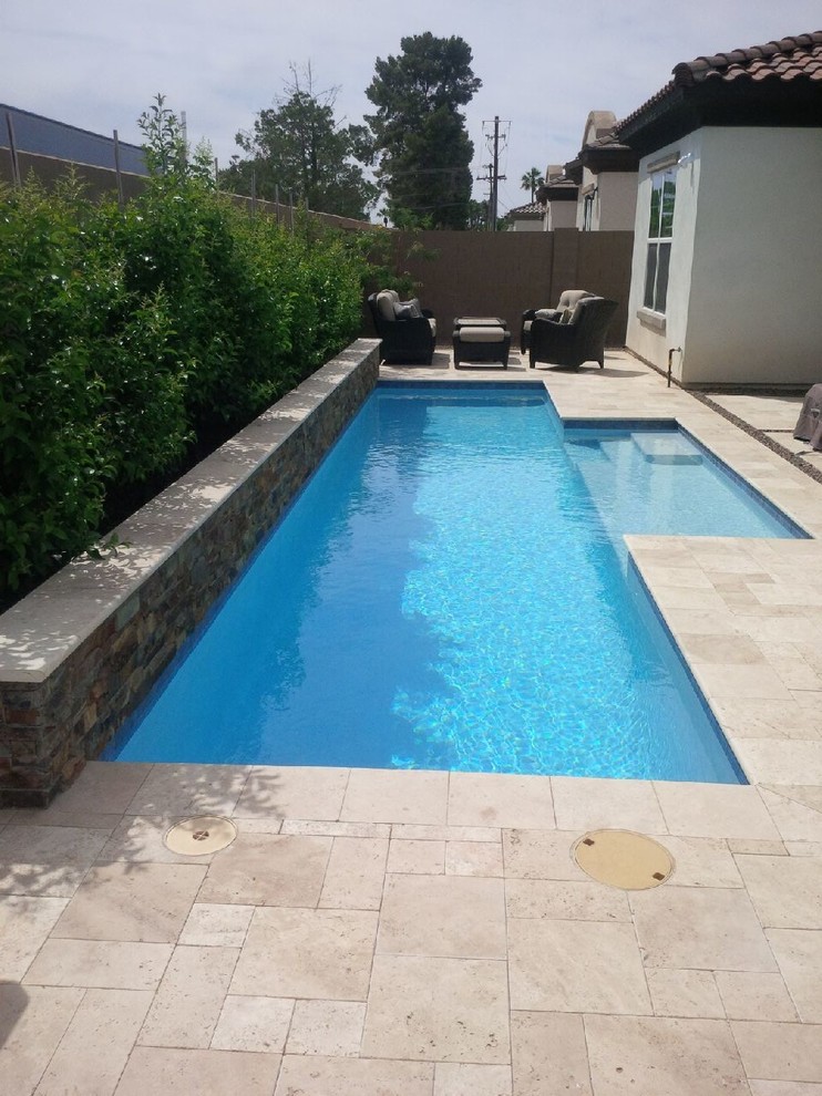 Ejemplo de piscina alargada actual de tamaño medio rectangular en patio trasero con suelo de baldosas