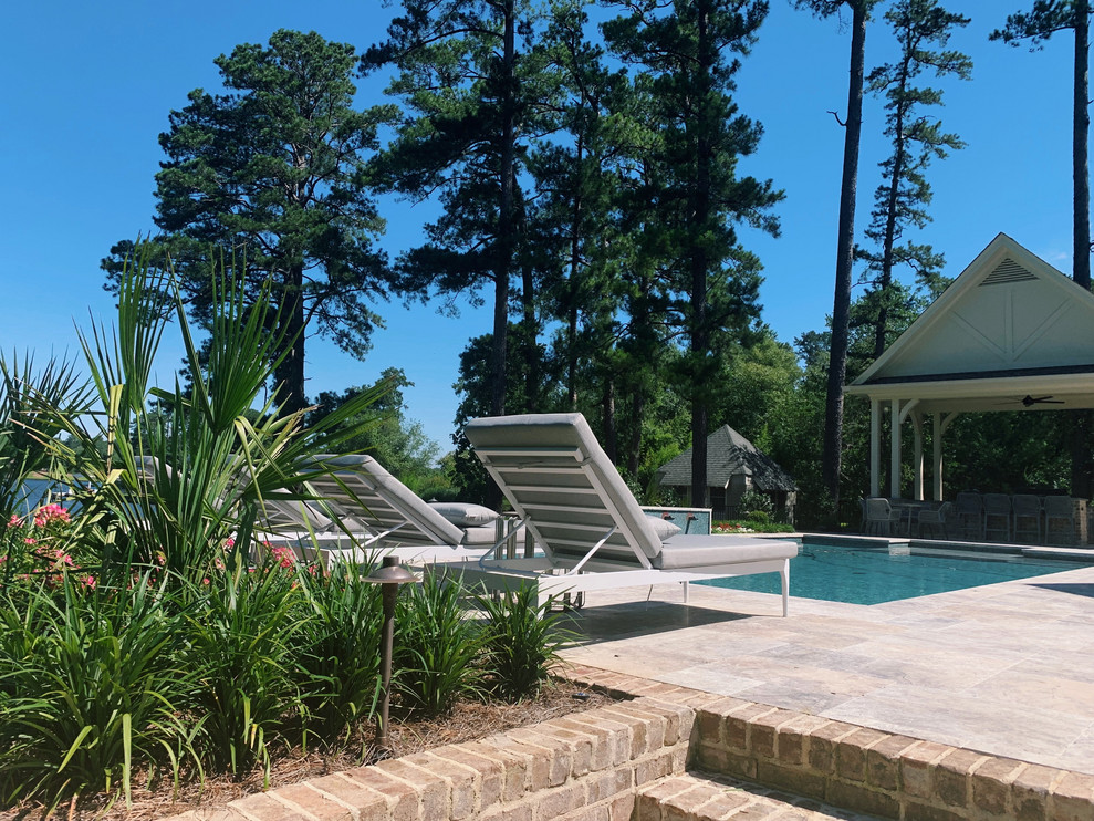 На фото: большой прямоугольный ландшафтный бассейн на заднем дворе в стиле модернизм с покрытием из каменной брусчатки