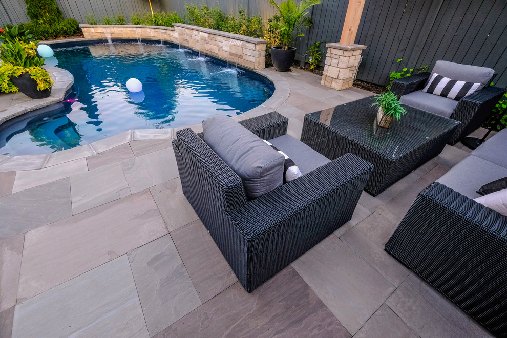 Foto de piscina clásica renovada pequeña tipo riñón en patio trasero con adoquines de piedra natural