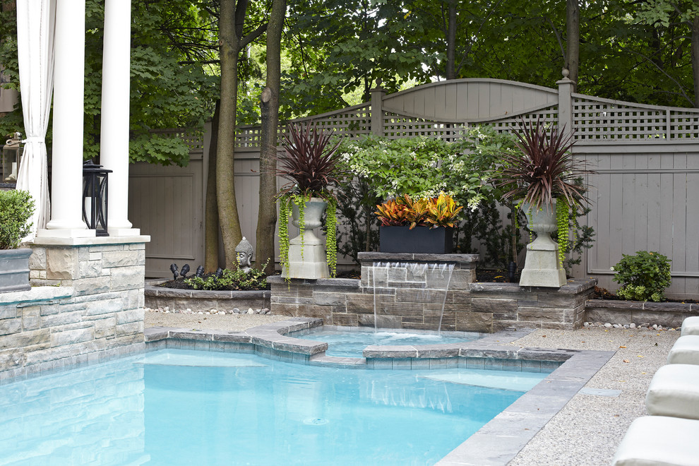 Esempio di una piscina monocorsia tradizionale rettangolare di medie dimensioni e dietro casa con una vasca idromassaggio e pavimentazioni in cemento
